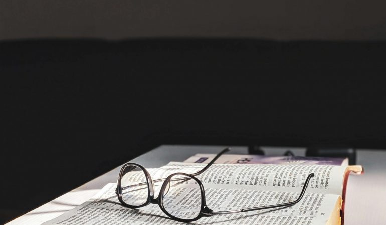 Libro con gafas en biblioteca estudiando grafologia